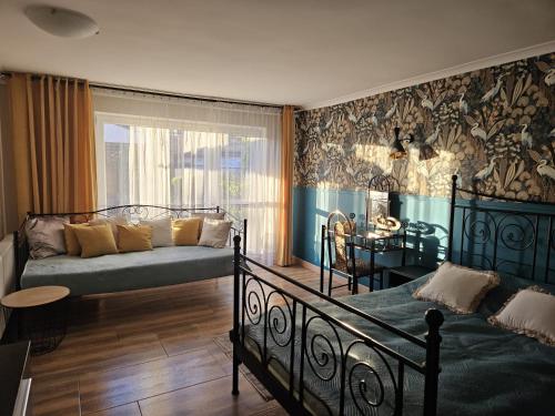 a bedroom with a bed and a couch in a room at Domki u Magdy in Ustka