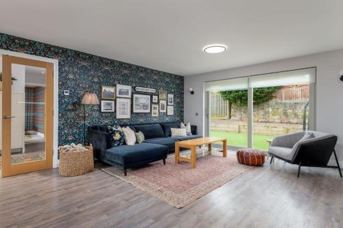 a living room with a blue couch and a table at Brunstane House - 15 mins to City Centre in Edinburgh