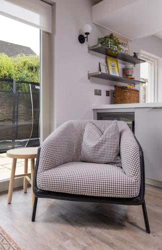 a chair in a living room with a table at Brunstane House - 15 mins to City Centre in Edinburgh