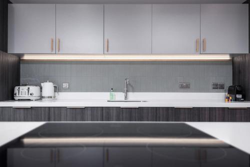 a kitchen with white cabinets and a sink at Brunstane House - 15 mins to City Centre in Edinburgh