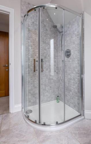 a shower with a glass enclosure in a bathroom at Brunstane House - 15 mins to City Centre in Edinburgh