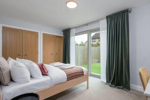 a bedroom with a bed and a large window at Brunstane House - 15 mins to City Centre in Edinburgh