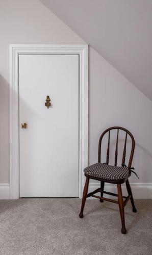 a wooden chair sitting in front of a door at Brunstane House - 15 mins to City Centre in Edinburgh
