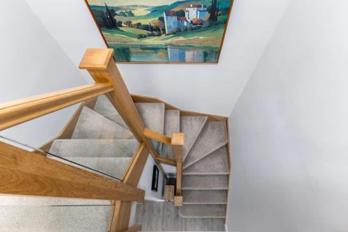 a staircase in a house with a painting on the wall at Brunstane House - 15 mins to City Centre in Edinburgh