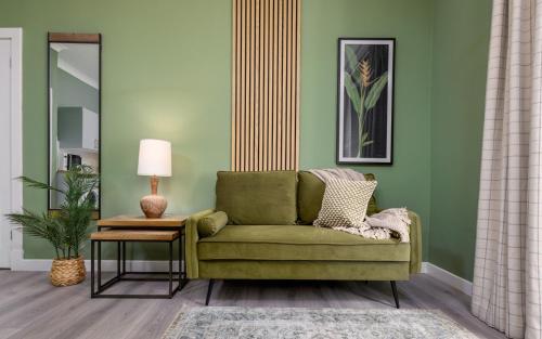 a living room with a green couch and a table at Ochill View Apartment by Stirling Train Station in Stirling