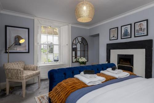 a bedroom with a blue bed and a fireplace at The Stirling Garden Townhouse - Private Courtyard in Stirling