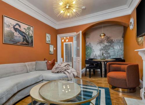 a living room with a couch and a table at Stylish Penthouse Retreat in Stirling