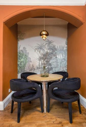 a dining room with a table and four chairs at Stylish Penthouse Retreat in Stirling