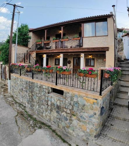 a house with flowers on a stone wall at Archontikon 1817 in Kaliana