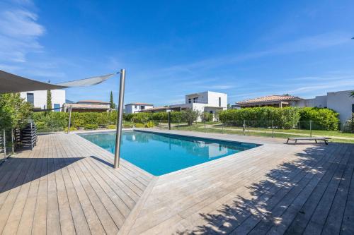 une piscine avec une terrasse en bois et un banc dans l'établissement Villa Baia T3 - Kids Friendly - Clim - 900m plages St Cyprien & Cala Rossa, à Lecci
