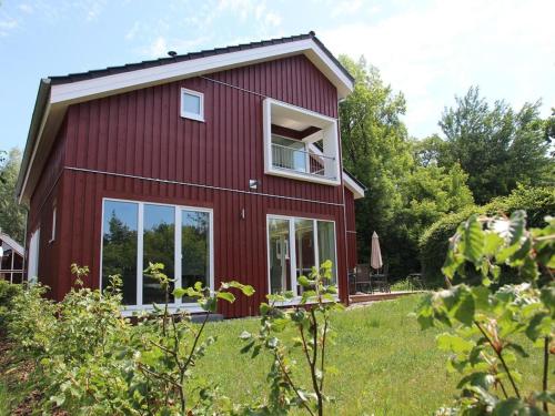 a red house with a large window on the side of it at Xxl Familienferienhaus in Rechlin