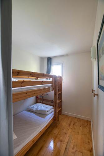 deux lits superposés dans une chambre avec fenêtre dans l'établissement Appartement n 24 pour 4 à 6 personnes plages à pied, à Capbreton