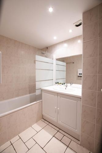 une salle de bain avec un lavabo blanc et un miroir dans l'établissement Appartement n 24 pour 4 à 6 personnes plages à pied, à Capbreton