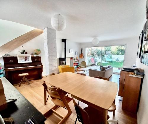 - un salon avec une table en bois et un piano dans l'établissement La Providence, à Toulouse