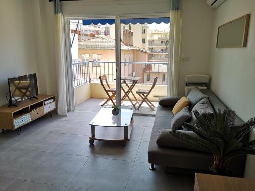 un salon avec un canapé, une table et une télévision dans l'établissement Charmant 2P au cœur de Juan-les-Pins, à Juan-les-Pins