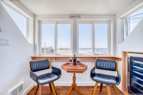 two chairs and a table in a room with windows at Walters Waldport in Waldport