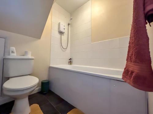 a bathroom with a toilet and a bath tub at Sherry's 2 Bed Guest House in Buckinghamshire