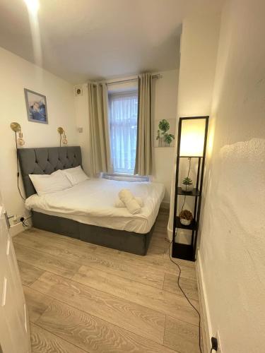 a small bedroom with a bed with a window at 2 bedroom flat ground floor NW1 in London