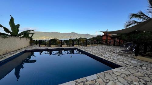 a swimming pool with a view of the water at Residencial Azul Marinho - Suítes por temporada in Ilhabela