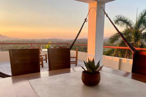 a table with a potted plant on top of a balcony at Vistas a las Montañas y al Mar I Condominio Las Calandrias I Alberca I Wi-Fi in Ixtapa