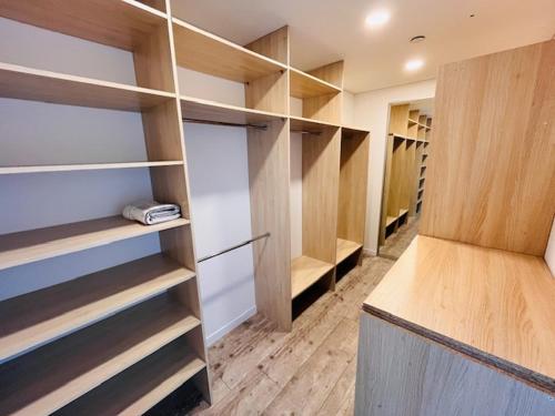 a walk in closet with wooden shelves and cabinets at Menulio Misko Nights in Vilkija