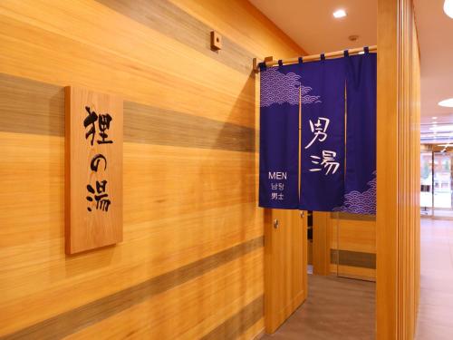 a hallway with wooden walls and signs on the wall at Dormy Inn Sapporo Annex in Sapporo