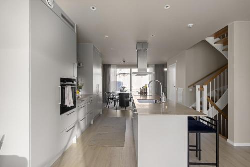 a kitchen with white cabinets and a kitchen island at Townhouse with Jacuzzi in Älta