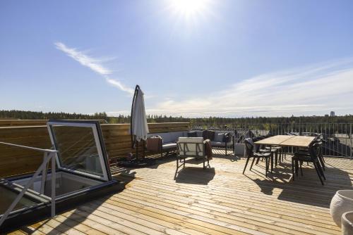 a deck with tables and chairs and an umbrella at Townhouse with Jacuzzi in Älta