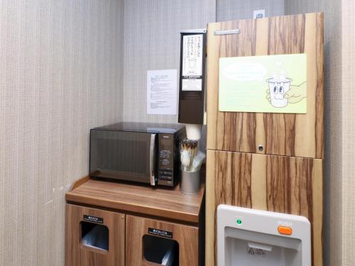 a room with a microwave and a small refrigerator at Dormy Inn Sapporo Annex in Sapporo