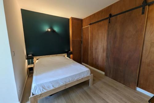 - une petite chambre avec un lit et un mur vert dans l'établissement Charming studio of 23 m in Saint-Nazaire, à Saint-Nazaire
