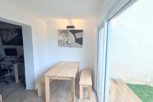 une table et un banc en bois dans une chambre avec fenêtre dans l'établissement Charming studio of 23 m in Saint-Nazaire, à Saint-Nazaire