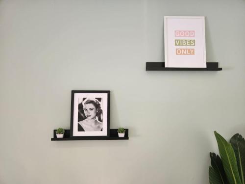 a shelf with two pictures on a white wall at Le refuge du Grand Vert in Grasse
