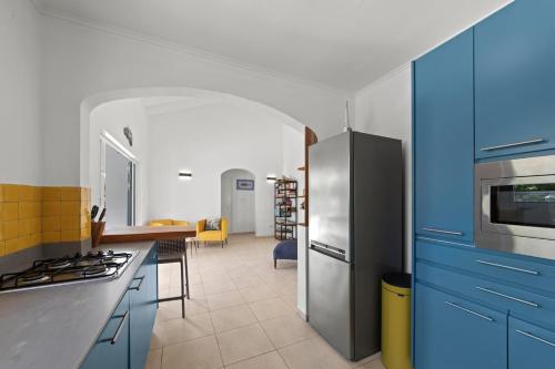 a kitchen with blue cabinets and a stainless steel refrigerator at Villa Monte Azul in Willemstad