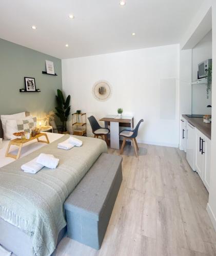 a bedroom with a bed and a table and chairs at Le refuge du Grand Vert in Grasse