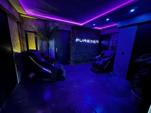 a dark room with purple lights and chairs in it at Spartementen by Pure-Zen in Rotterdam