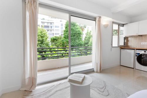 Il comprend un salon avec une grande fenêtre et une cuisine. dans l'établissement Le Palais - Hypercentre - Croisette - Calm - AC, à Cannes