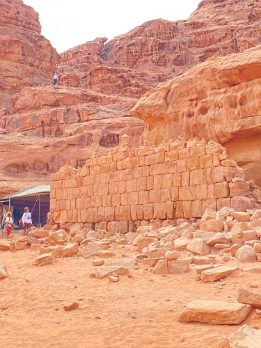 a stone wall in the desert near a mountain at Star Wars luxury camp in Wadi Rum