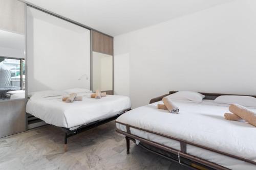 deux lits dans une chambre avec un miroir dans l'établissement Le Majestic - Hypercentre - Croisette - AC, à Cannes