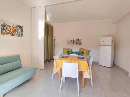 una sala da pranzo con un tavolo e un divano di Lemon Tree Home ad Aci Castello