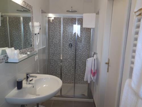 a bathroom with a sink and a shower at Hotel Lupori in Viareggio