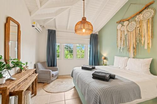 Un dormitorio con una cama grande y una silla. en Spanish Keys Penthouse, en Jan Thiel
