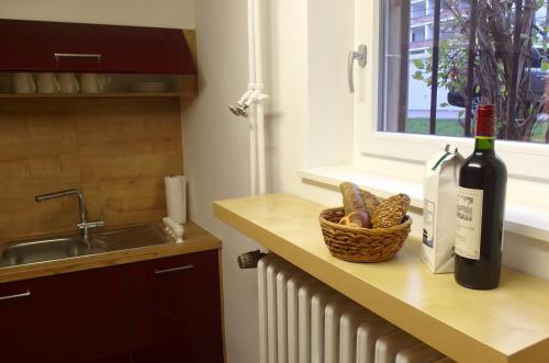 una barra de cocina con una botella de vino y una cesta de pan en Am Forsthaus Gravenbruch, en Gravenbruch