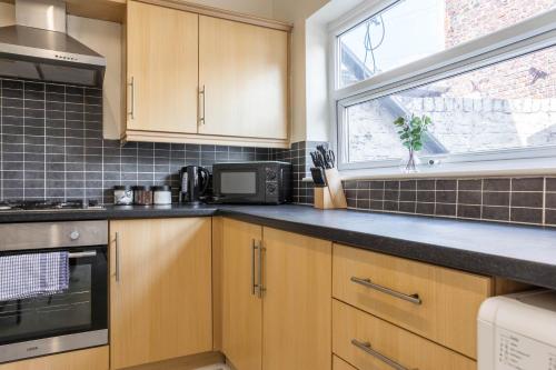 リバプールにあるFree Parking, 4 Bed, 2 Bath House, Long Term Stay Savings, Contractors, Near Anfieldのキッチン(木製キャビネット付)、窓