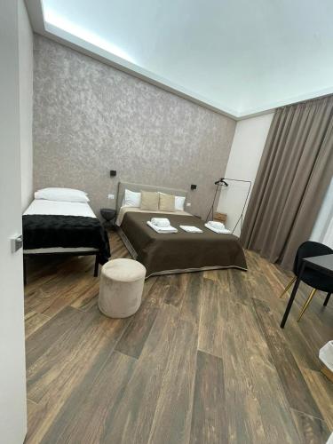 a bedroom with two beds and a table in it at Lustru Apartment in Catania