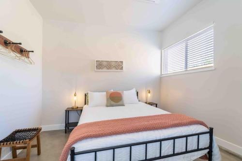 a white bedroom with a bed and a window at Morrison Getaway - 2BR House BBQ Free Parking in Morrison