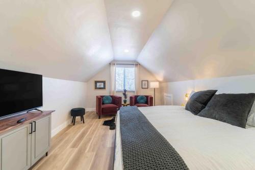 a bedroom with a large bed and a flat screen tv at Morrison Getaway - 2BR House BBQ Free Parking in Morrison