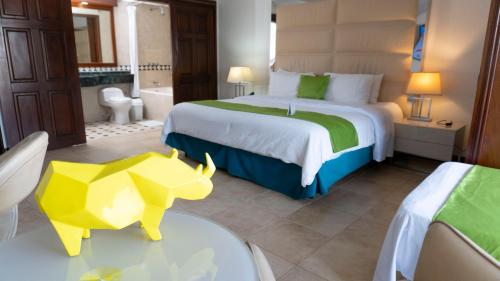 a hotel room with a bed with a yellow cow on a table at Hotel Windsor Barranquilla in Barranquilla