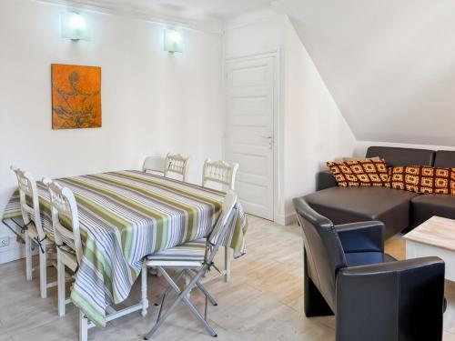 a dining room with a table and chairs and a couch at La maison Hortensias Vic-Sur-Cère - 6pers in Vic-sur-Cère