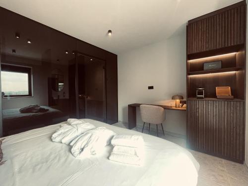 a bedroom with a large white bed and a desk at Domaine Sur Les Sarts in Ohey