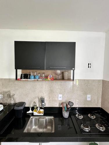 a kitchen with a sink and a stove top oven at Apartamento Próximo ao Aeroporto e Rodoviária in Palmas